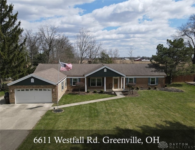 view of front of house with fence, an attached garage, concrete driveway, a front yard, and brick siding