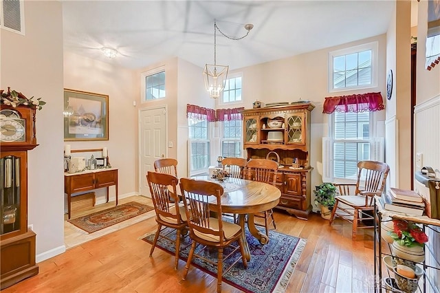 3949 E Summit Ridge Dr, Beavercreek, OH 45430 - dining space featuring light wood finished floors, a high ceiling, and a chandelier