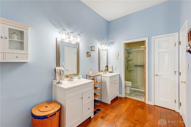 3949 E Summit Ridge Dr, Beavercreek, OH 45430 - bathroom featuring a shower stall, hardwood / wood-style flooring, two vanities, and toilet