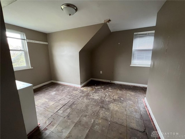 bonus room with baseboards and lofted ceiling