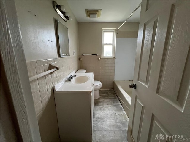 full bathroom with toilet, vanity, shower / tub combination, and tile walls