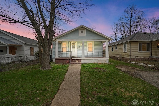 view of front of home with fence, a front lawn, and a porch