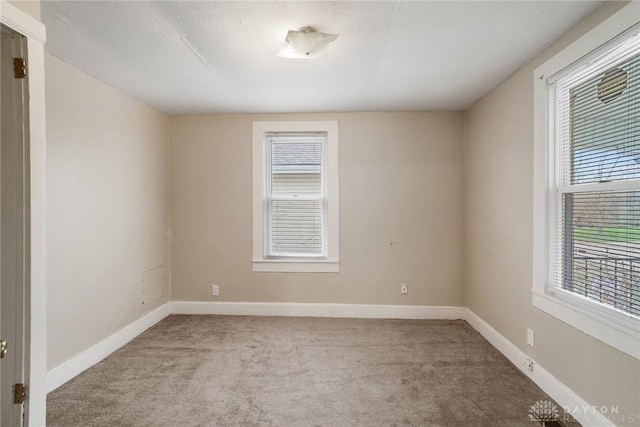 empty room featuring carpet floors and baseboards