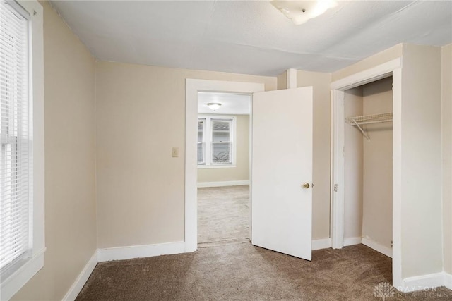 unfurnished bedroom with baseboards, a closet, and carpet