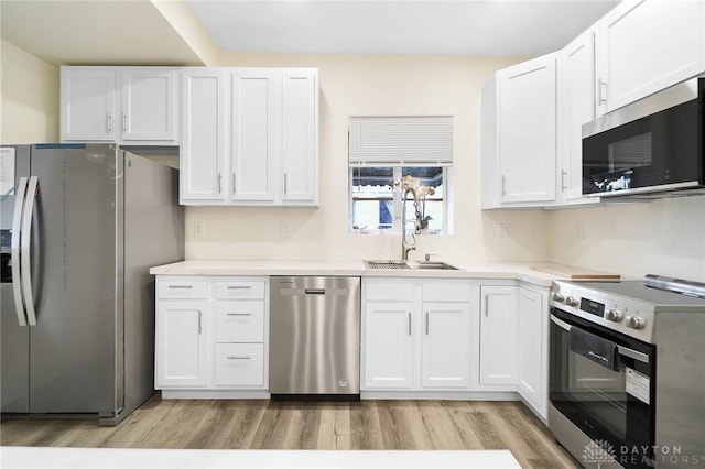 1615 Carrollton Ave, Dayton, OH 45409 - kitchen with white cabinetry, light countertops, stainless steel appliances, a sink, and light wood finished floors