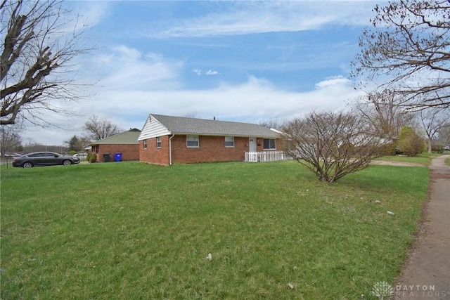 exterior space with brick siding and a yard