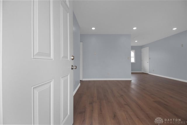 empty room featuring recessed lighting, baseboards, and dark wood finished floors