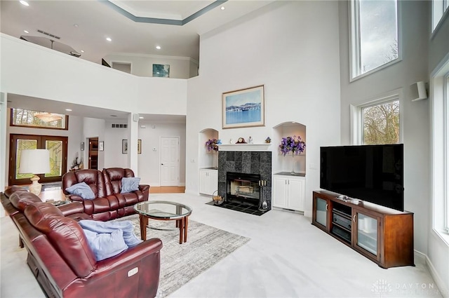 3558 Golden Fox Trl, Lebanon, OH 45036 - living room with a tile fireplace, light colored carpet, crown molding, and a high ceiling