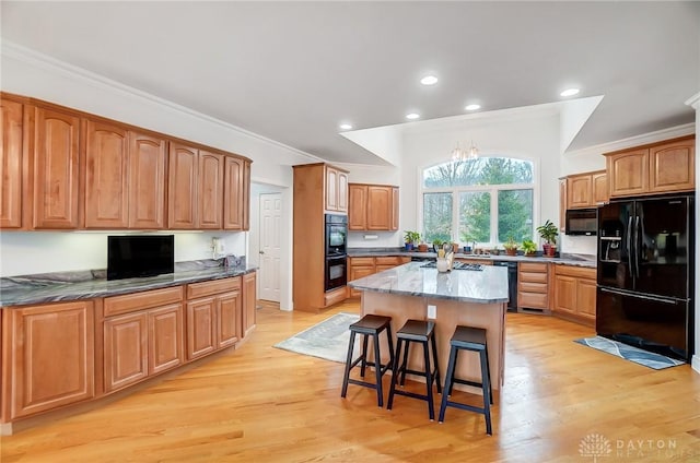 3558 Golden Fox Trl, Lebanon, OH 45036 - kitchen featuring a kitchen bar, light wood-type flooring, crown molding, black appliances, and a center island