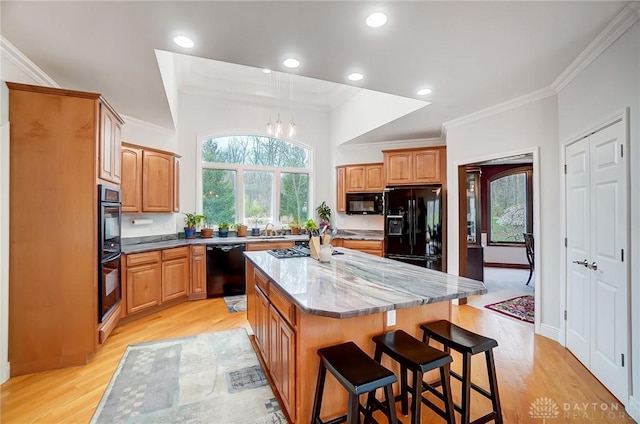 3558 Golden Fox Trl, Lebanon, OH 45036 - kitchen featuring black appliances, light wood finished floors, a kitchen island, and plenty of natural light