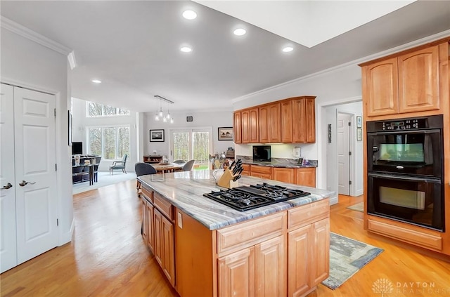 3558 Golden Fox Trl, Lebanon, OH 45036 - kitchen with light stone counters, light wood-style flooring, a kitchen island, black appliances, and ornamental molding