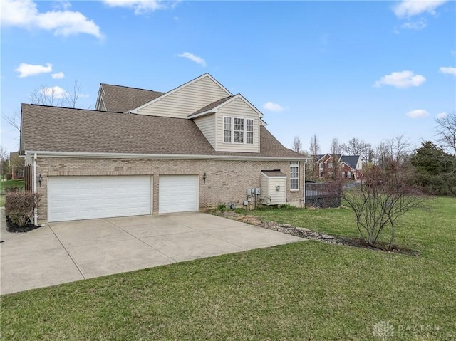 view of front of house with roof with shingles, an attached garage, driveway, a front yard, and brick siding