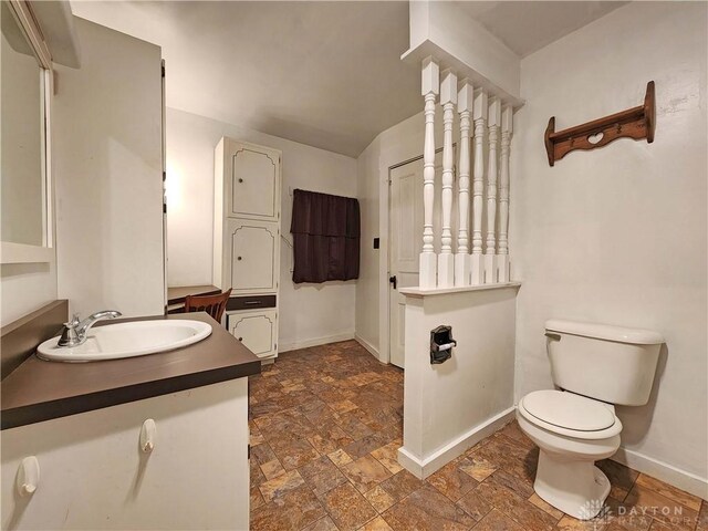 5469 Davis Rd, Jamestown Vlg, OH 45335 - bathroom featuring baseboards, toilet, stone finish flooring, and vanity