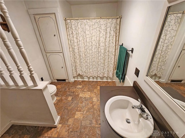 5469 Davis Rd, Jamestown Vlg, OH 45335 - bathroom with toilet, vanity, curtained shower, stone finish floor, and baseboards