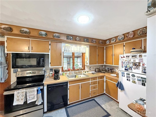 kitchen featuring black appliances, light countertops, and a sink