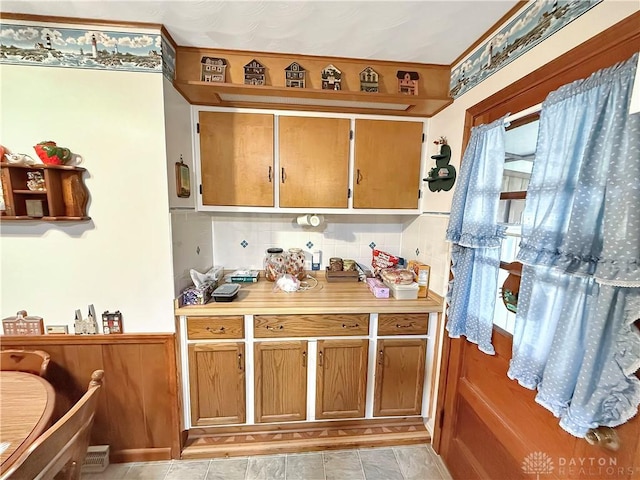 kitchen featuring brown cabinets, light countertops, and decorative backsplash