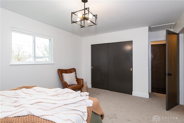 carpeted bedroom with an inviting chandelier and a closet
