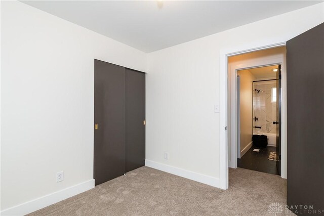 unfurnished bedroom with baseboards, a closet, and carpet floors
