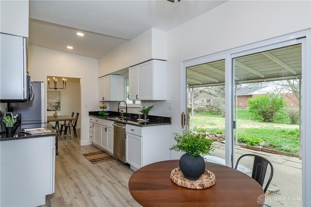 kitchen with a sink, white cabinetry, light wood-style flooring, stainless steel appliances, and recessed lighting