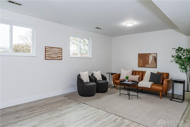living room featuring baseboards, visible vents, and wood finished floors