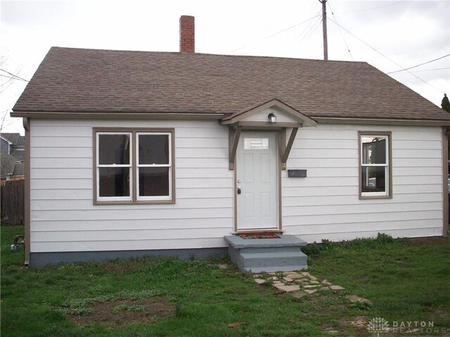 4 Verity St, Jamestown Vlg, OH 45335 - view of front facade featuring a chimney, a shingled roof, and a front yard