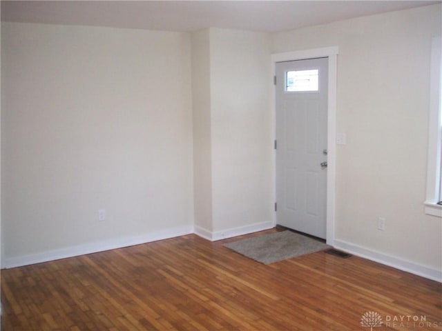 foyer entrance with baseboards and wood finished floors