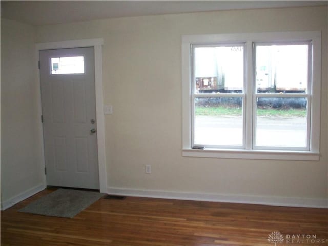 foyer entrance with visible vents, baseboards, and wood finished floors