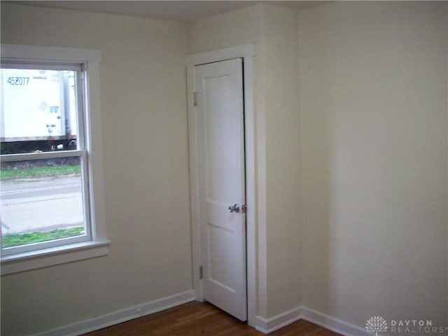 empty room with baseboards and wood finished floors