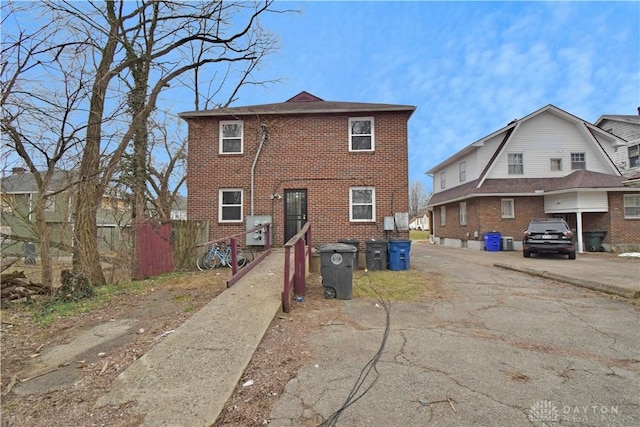 back of property featuring brick siding and fence