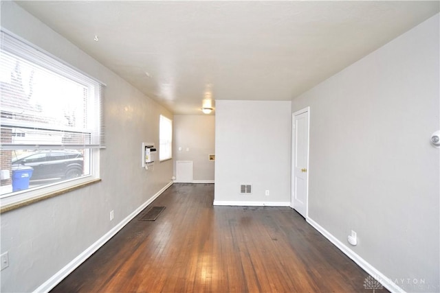 spare room featuring hardwood / wood-style floors, baseboards, and visible vents