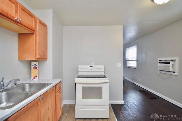 kitchen with a sink, an AC wall unit, white electric range, and wood finished floors