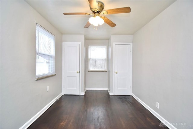 unfurnished room with baseboards, a ceiling fan, and dark wood-style floors