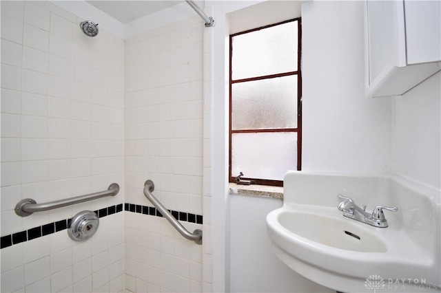 bathroom with a sink and tiled shower