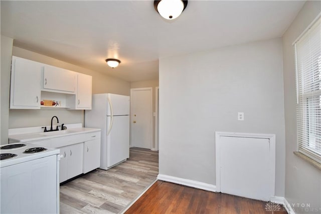 kitchen featuring open shelves, white appliances, a sink, light wood-style floors, and white cabinets