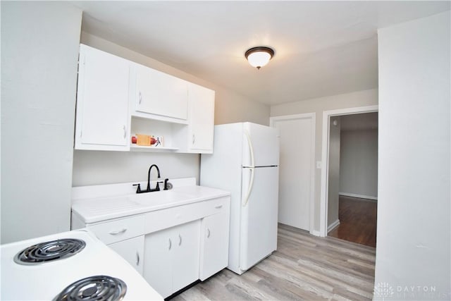 kitchen featuring white cabinetry, light countertops, open shelves, a sink, and freestanding refrigerator