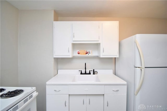 kitchen with light countertops, open shelves, white appliances, a sink, and white cabinets
