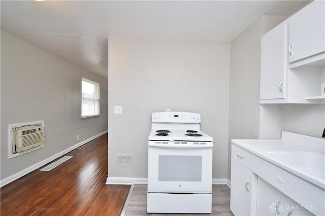 kitchen featuring a wall mounted air conditioner, white cabinetry, visible vents, and white range with electric cooktop