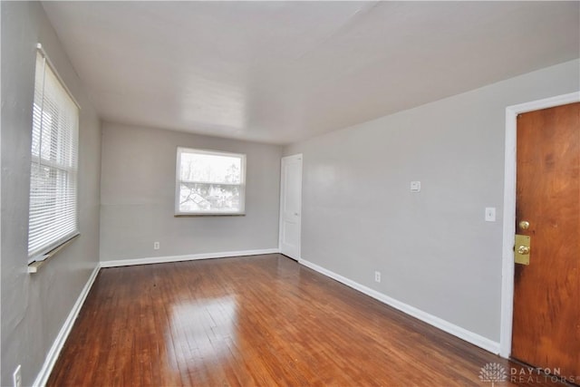 empty room featuring hardwood / wood-style flooring, a healthy amount of sunlight, and baseboards
