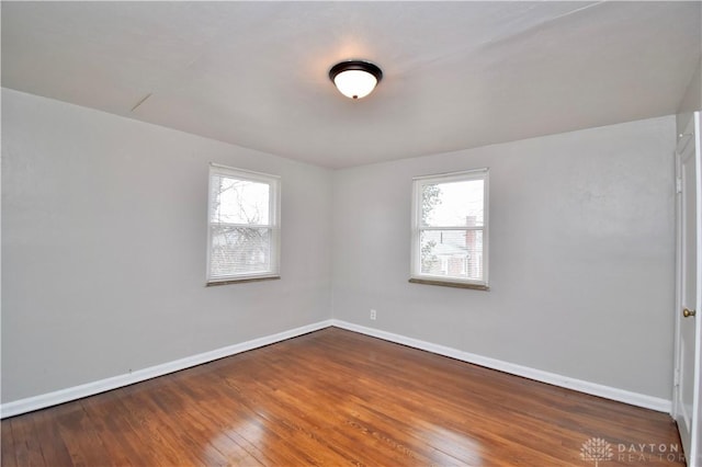unfurnished room featuring hardwood / wood-style floors, plenty of natural light, and baseboards