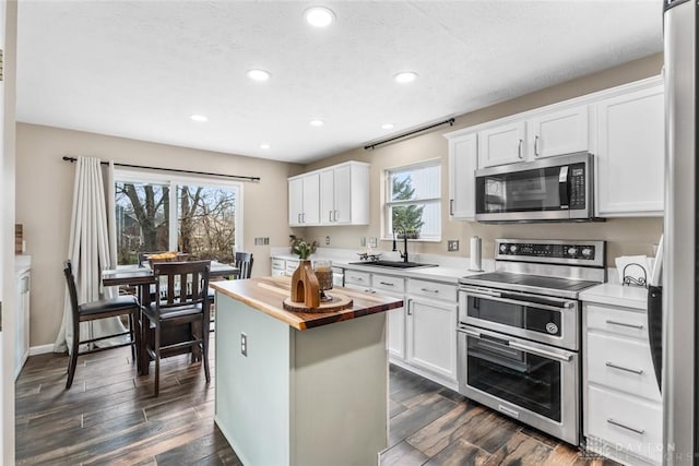 kitchen featuring a sink, appliances with stainless steel finishes, recessed lighting, and butcher block counters