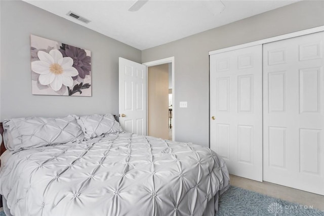 carpeted bedroom featuring ceiling fan, a closet, and visible vents