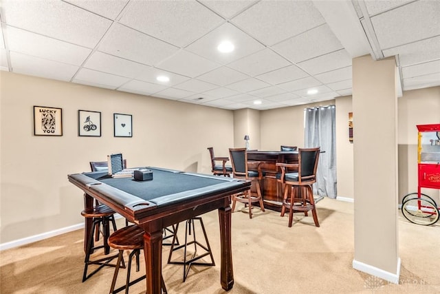 game room with baseboards, light colored carpet, a dry bar, and a drop ceiling