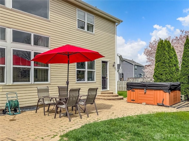 back of property featuring a hot tub, a patio area, and entry steps