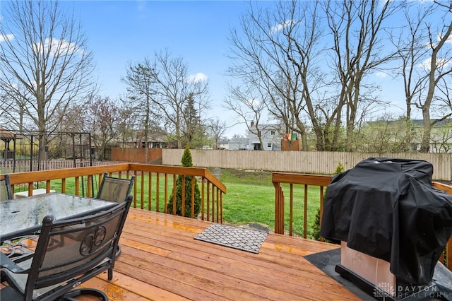 wooden terrace with a yard, a fenced backyard, outdoor dining space, and a grill