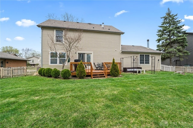 rear view of property featuring a yard, a wooden deck, and fence
