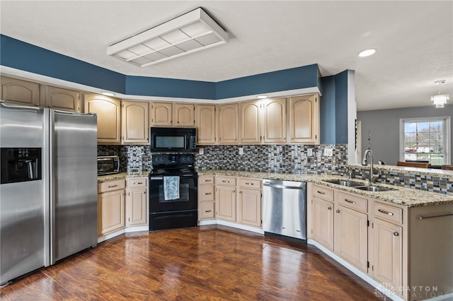 kitchen featuring a sink, backsplash, black appliances, and a peninsula