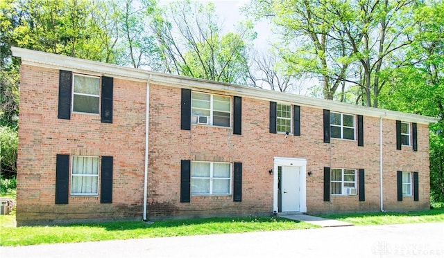 view of front facade featuring brick siding and central air condition unit