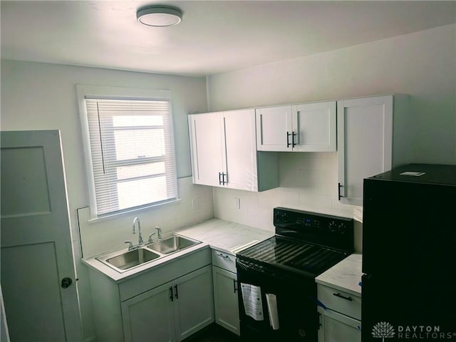 kitchen featuring green cabinetry, decorative backsplash, a sink, black range with electric cooktop, and white cabinets