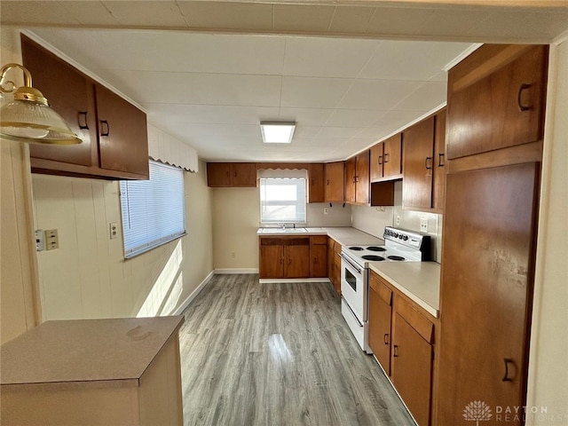 4322 Annapolis Ave, Dayton, OH 45416 - kitchen featuring light countertops, a sink, light wood-type flooring, brown cabinetry, and white electric range oven