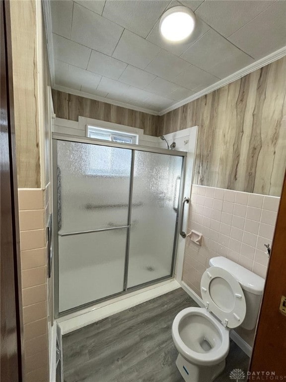 4322 Annapolis Ave, Dayton, OH 45416 - bathroom with crown molding, toilet, a shower stall, wood finished floors, and tile walls
